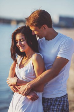 Yaz aylarında sahilde sevgi dolu genç bir çift yürüyüş