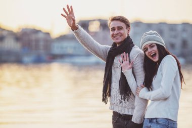 Sevgi dolu genç çift sahilde sonbaharda yürümek.