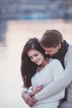 Sevgi dolu genç çift sahilde sonbaharda yürümek.