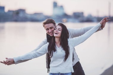 Sevgi dolu genç çift sahilde sonbaharda yürümek.