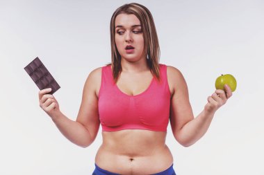 Sağlıklı beslenme kavramı. Beyaz bir arka plan üzerinde şişman kadın diyet izole