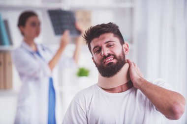 Yaralanma boyun. Yaralı boyun olan genç adam. Genç kadın doktor hasta yardımcı olur.