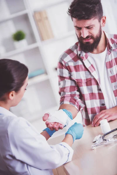 Mani Ferite Giovanotto Con Mani Ferite Giovane Medico Donna Aiuta — Foto Stock