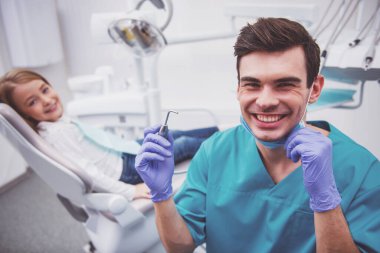 Dişçideki küçük güzel kız kameraya bakıyor ve gülümsüyor.