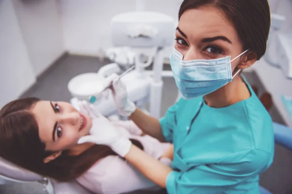 若い女性歯科医が患者の歯を調べ — ストック写真
