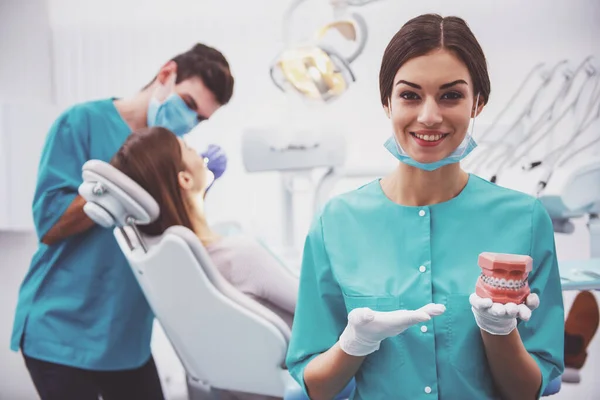 Jovem Assistente Segurando Modelo Dentes Plástico Dentista Fundo Trata Paciente — Fotografia de Stock