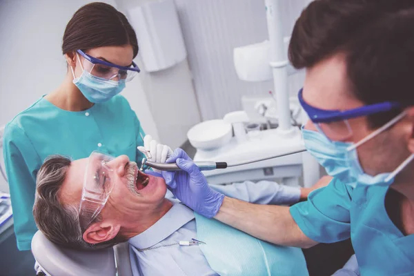 Young Dentist His Assistant Treating Elderly Man — Stock Photo, Image