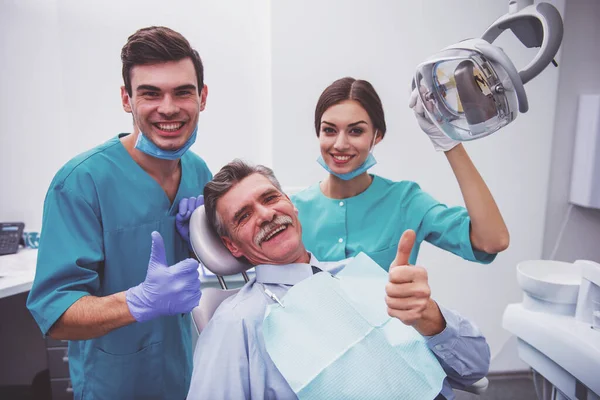 Joven Doctor Dentista Asistente Paciente Anciano Mostrando Pulgar Hacia Arriba — Foto de Stock