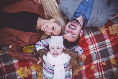 Mutlu genç aile sonbahar parkta yürürken battaniye var yalan. En iyi gözden geçirme