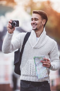 Genç turizm şehrin içinden bir yürüyüş sırasında kamera kullanımı