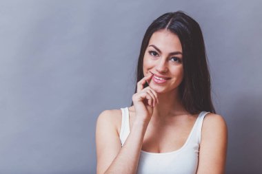 Kamera, gri bir arka plan üzerine bakarak onların duyguları ifade stüdyoda, poz güzel genç kadın