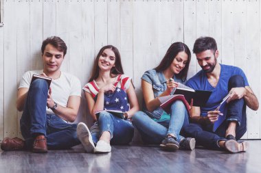 Bir defterde yazılı katta oturan dört çekici genç arkadaşlar