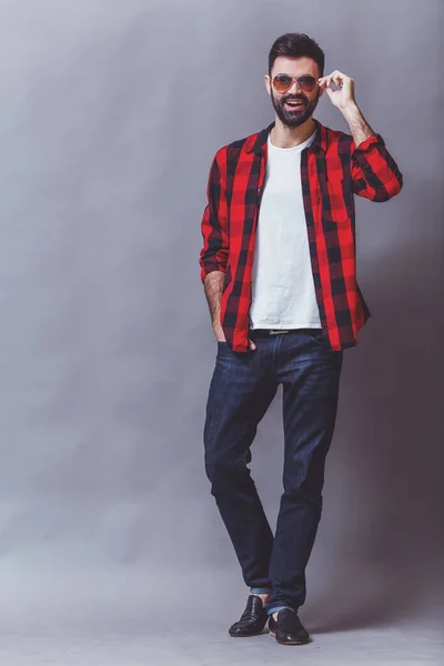 Young Handsome Man Checkered Shirt Dark Jeans Holding Glasses Gray — Stock Photo, Image