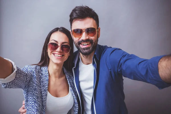 Giovane Bella Coppia Che Occhiali Uno Sfondo Grigio — Foto Stock