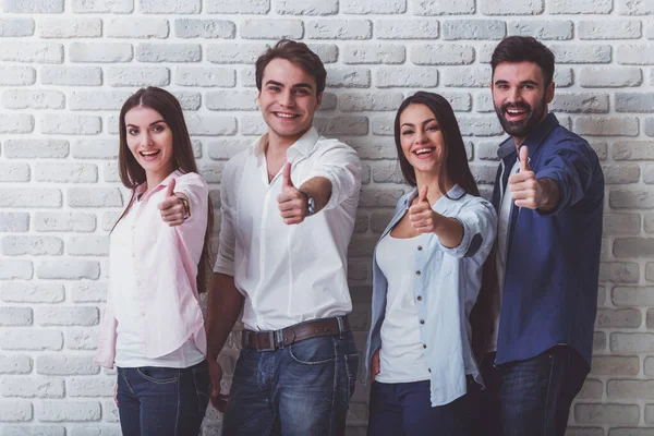 Grupo Jóvenes Atractivos Mirando Cámara Sonriendo Mostrando Pulgares Hacia Arriba — Foto de Stock