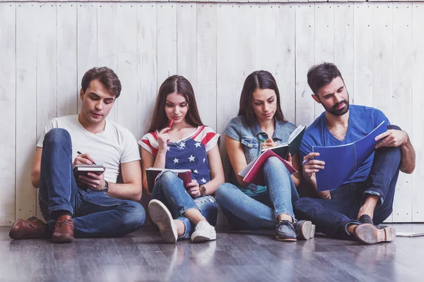 Cuatro Jóvenes Amigos Atractivos Sentados Suelo Escribiendo Cuaderno — Foto de Stock