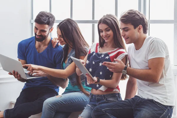 Cuatro Jóvenes Atractivos Usando Ordenador Portátil Tableta Sentado Alféizar Ventana — Foto de Stock