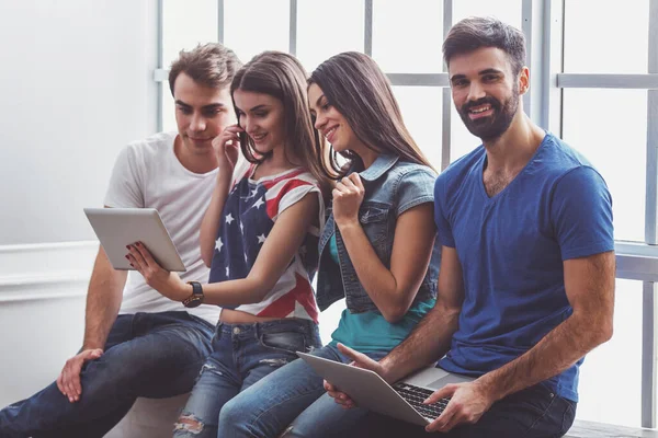 Czterech Młodych Ludzi Atrakcyjne Pomocą Laptopa Tablet Siedząc Parapecie Uśmiechając — Zdjęcie stockowe