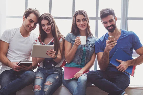 Cuatro Jóvenes Atractivos Que Mantienen Mano Tableta Taza Teléfono Inteligente — Foto de Stock