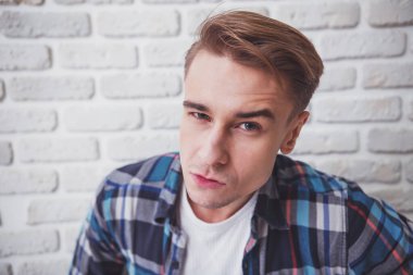 Rahat kıyafetler güzel genç adam olun selfie arka plan beyaz tuğla duvar üzerinde