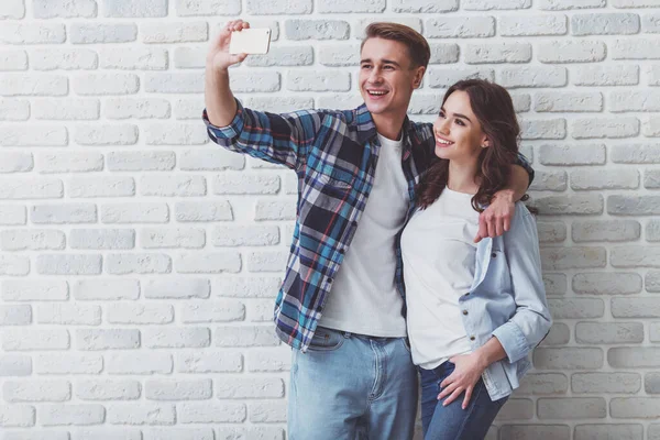 Glückliches Junges Paar Macht Selfie Stilvoller Kleidung Auf Backsteinmauer Hintergrund — Stockfoto