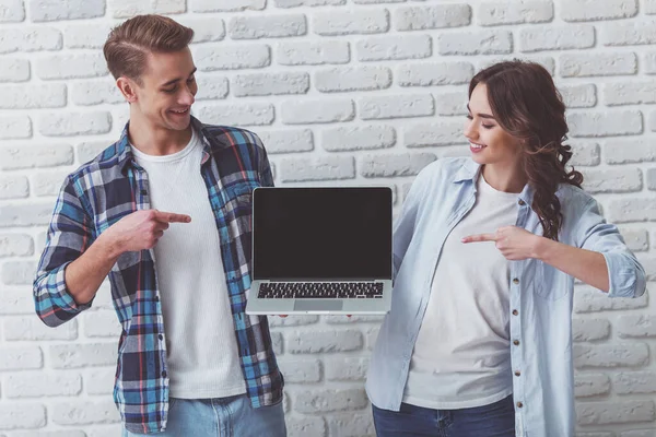 Счастливая Молодая Пара Укажет Пальцем Пустой Черный Экран Ноутбука Фоне — стоковое фото