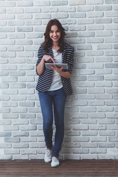 Szczęśliwa Młoda Kobieta Pomocą Tabletu Ubrany Ubranie Tle Ściany Cegła — Zdjęcie stockowe