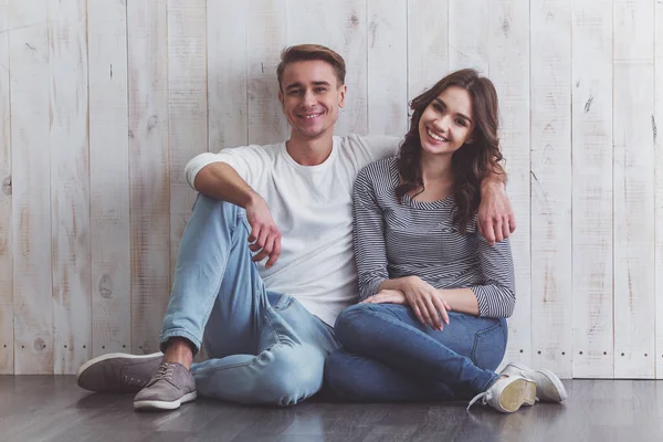 Belo Jovem Casal Sentado Chão Madeira Sorrindo Roupas Cotidianas Casa — Fotografia de Stock