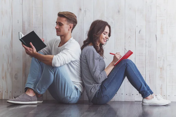 Beautiful Young Couple Writing Notebook Sitting Wooden Floor Home — Stock Photo, Image