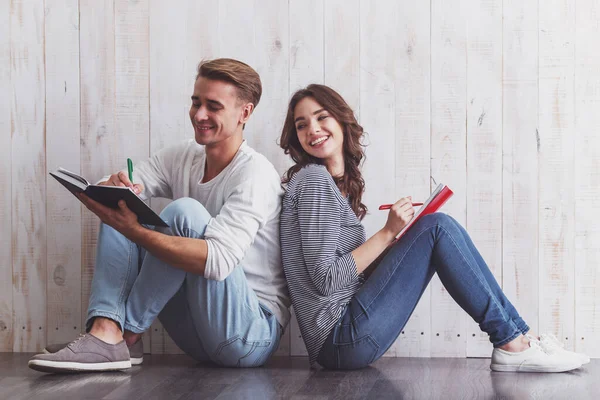 Beautiful Young Couple Writing Notebook Sitting Wooden Floor Home — Stock Photo, Image