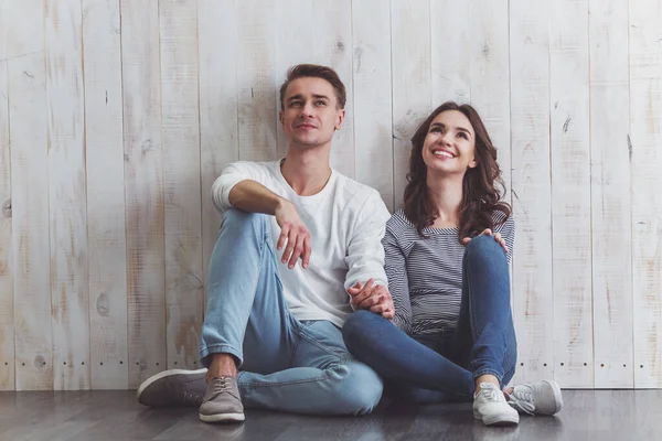 Belo Jovem Casal Sentado Chão Madeira Sorrindo Roupas Cotidianas Casa — Fotografia de Stock