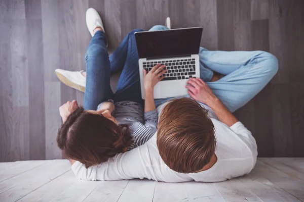 Pasangan Muda Duduk Lantai Kayu Menggunakan Laptop Rumah — Stok Foto