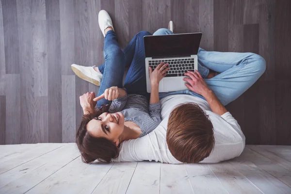 Junges Paar Sitzt Auf Holzboden Und Benutzt Hause Einen Laptop — Stockfoto