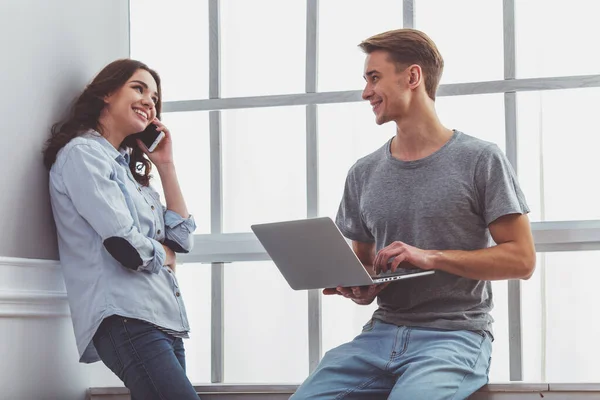 Happy Couple Uses Laptop Talking Phone While Standing Windowsills Home — Stock Photo, Image