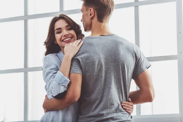 Jovem Casal Bonito Abraçar Enquanto Está Perto Uma Janela Casa — Fotografia de Stock