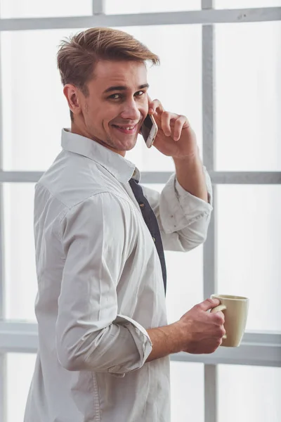 Красивый Молодой Человек Расстегнутой Белой Рубашке Разговаривает Телефону Держит Чашку — стоковое фото