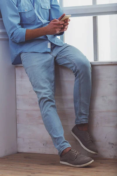 Bellissimo Giovanotto Camicia Blu Jeans Leggeri Usando Smartphone Seduto Sul — Foto Stock