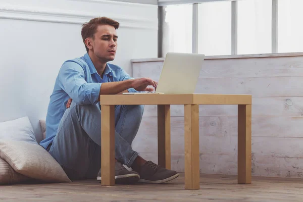 Красивый Молодой Человек Голубой Рубашке Легких Джинсах Использовать Ноутбук Столом — стоковое фото