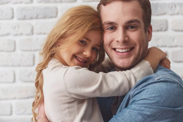 Linda Niña Abrazando Hermoso Padre Joven Mirando Cámara Sonriendo Mientras — Foto de Stock
