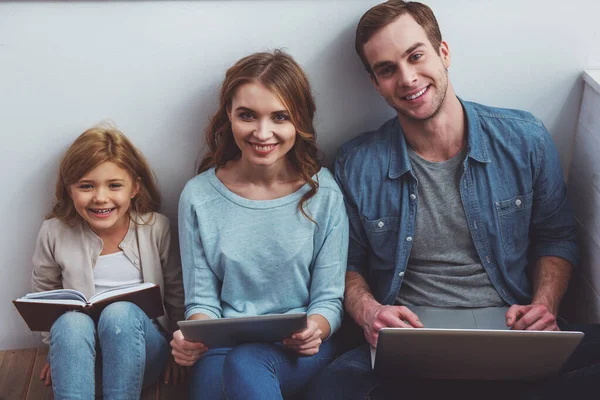 Hermosa Familia Joven Mirando Cámara Sonriendo Mientras Sienta Suelo Cerca — Foto de Stock