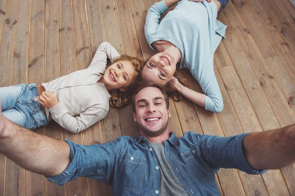 Bovenaanzicht Van Mooie Jonge Familie Kijken Camera Glimlachen Terwijl Liggend — Stockfoto