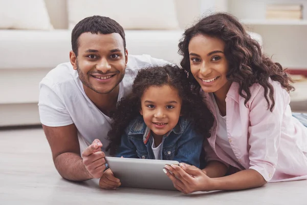 Linda Niña Afroamericana Sus Hermosos Padres Jóvenes Usando Una Tableta —  Fotos de Stock