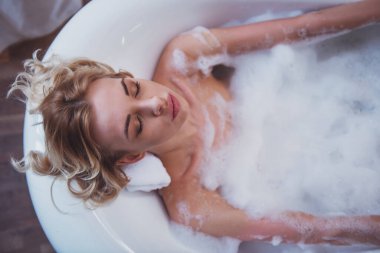 Kapalı gözlerle yalan köpük, keyifli banyo keyfi güzel genç sarışın kadının Üstten Görünüm