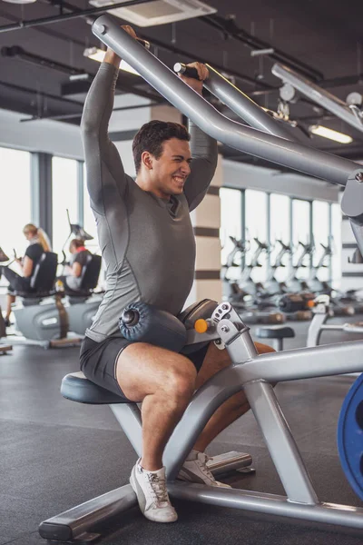 Demir pompalama spor salonu, fitness merkezinde egzersiz çekici genç kaslı adam