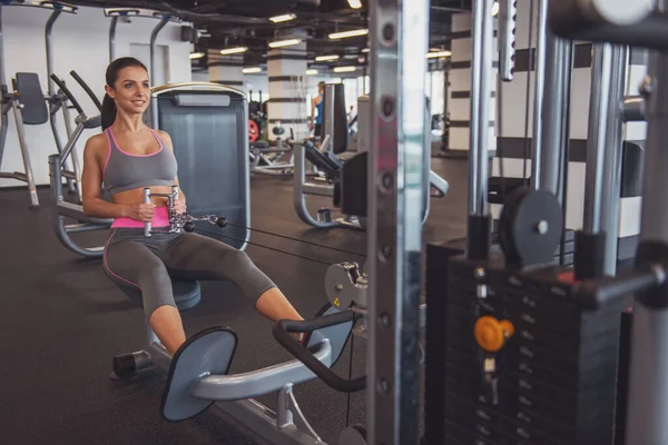 Spor salonu fitness merkezinde egzersiz, demir pompalama ve gülümseyen çekici genç kadın