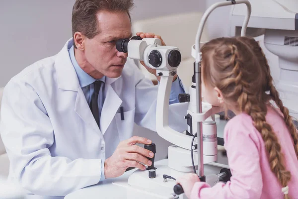 Gutaussehender Augenarzt Mittleren Alters Untersucht Die Augen Eines Kleinen Mädchens — Stockfoto