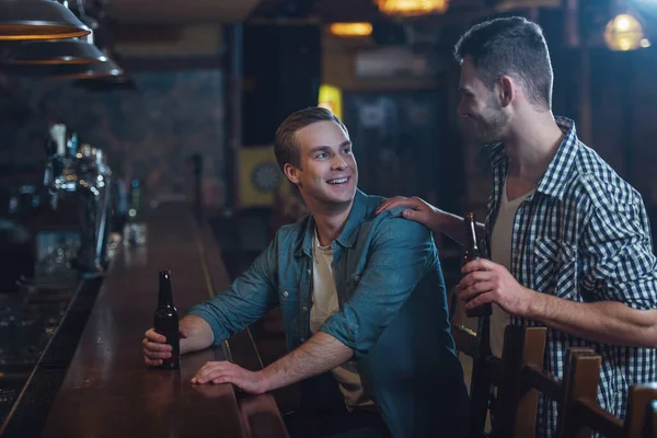 Двоє Молодих Чоловіків Повсякденному Одязі Посміхаються Розмовляють Тримають Пляшку Пива — стокове фото