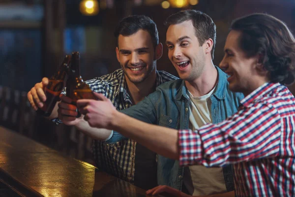 Drie Jonge Mannen Casual Kleding Zijn Glimlachend Rinkelende Flessen Bier — Stockfoto