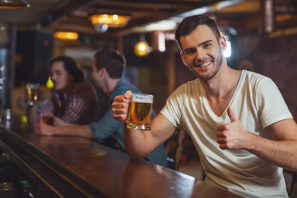 Joven Con Camiseta Blanca Sonríe Mirando Cámara Mostrando Signo Bebiendo — Foto de Stock