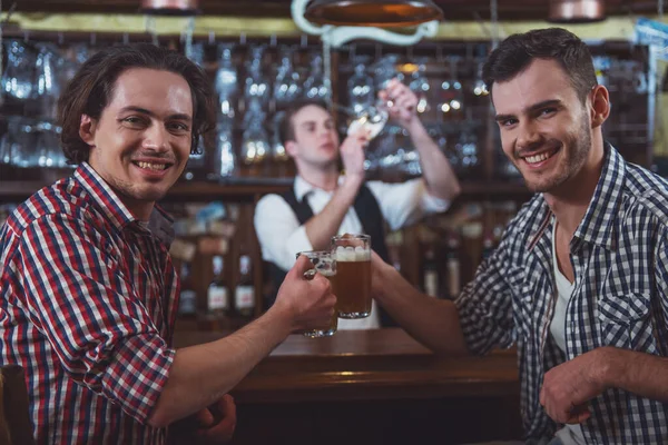 Dos Hombres Sonríen Mirando Cámara Colgando Vasos Cerveza Juntos Mientras —  Fotos de Stock